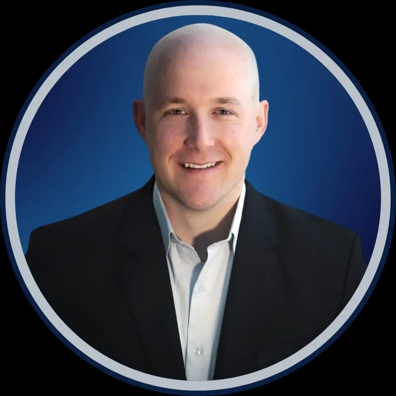 Smiling person in a suit, blue background.